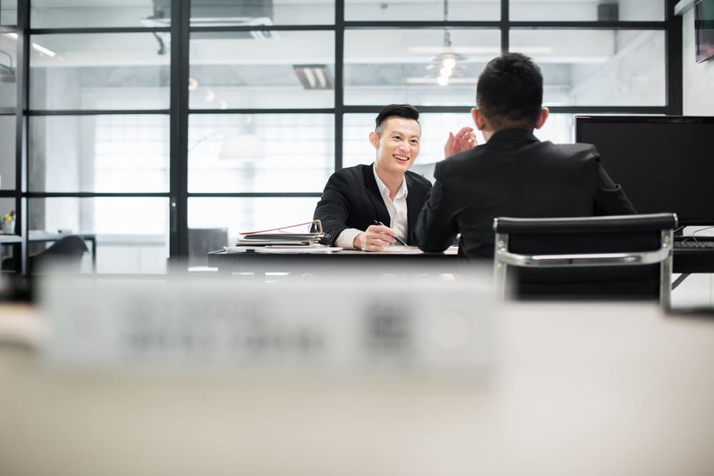 พนักงานชาย 2 คนกำลังคุยกันเรื่องค่าคอมมิชชั่น