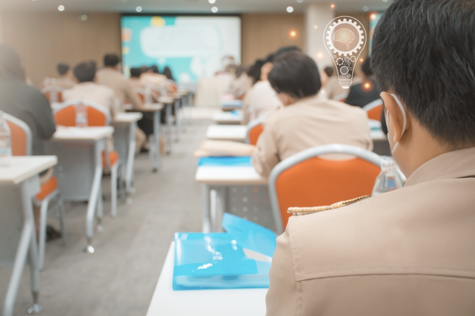 ข้าราชการกลุ่มหนึ่งนั่งฟังบรรยายในห้องสัมมนา แสดงถึงการอบรมหรือประชุมเพื่อพัฒนาความรู้และทักษะในการทำงาน